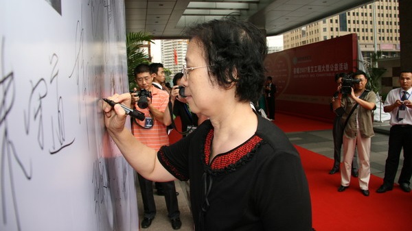 中华慈善总会副会长彭玉女士在爱心板上签名